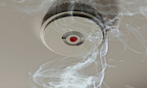Illustration of a smoke alarm sounding off in a smoky room Illustration of a smoke alarm sounding off in a smoky room